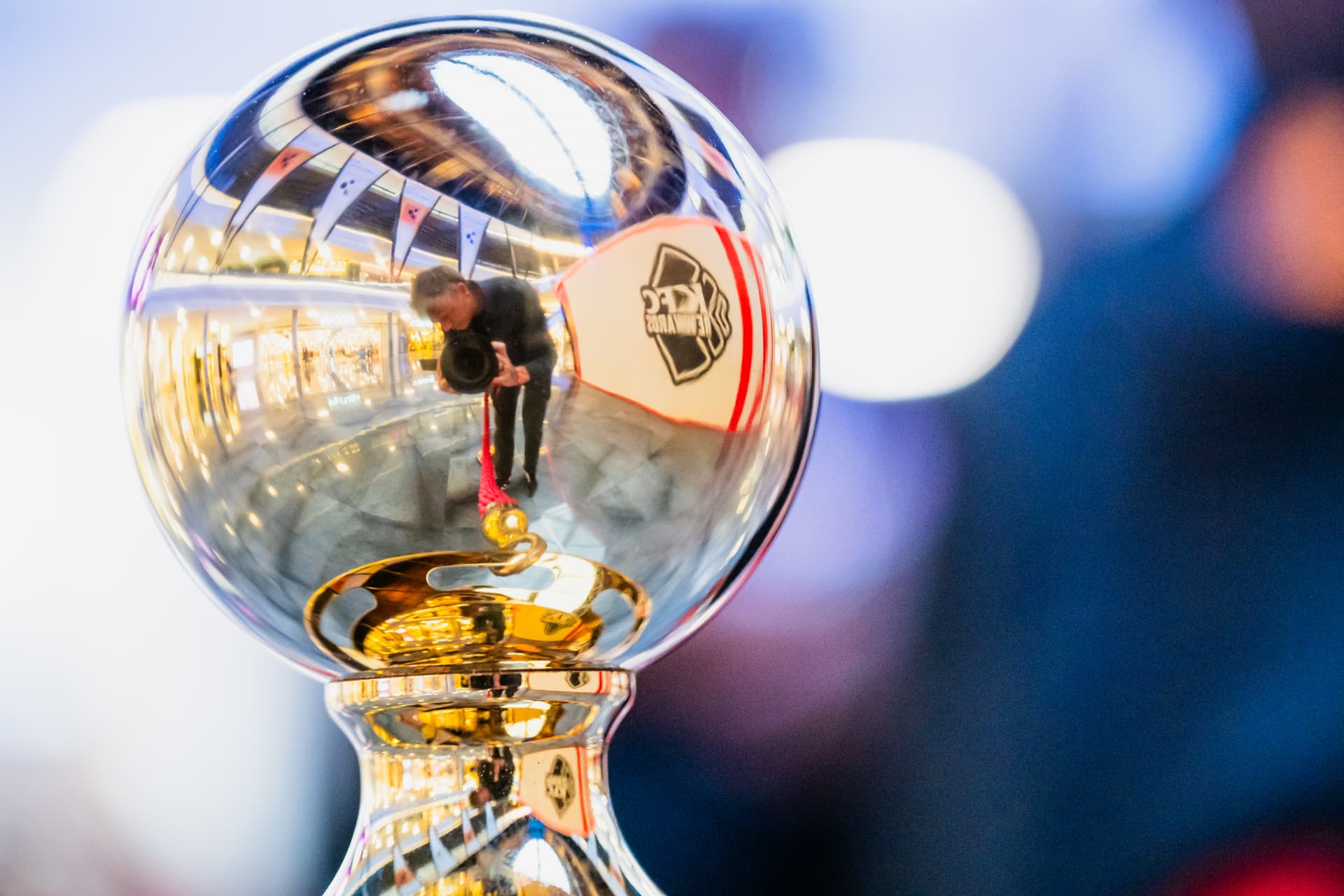 Close-up of a polished chrome trophy top reflecting the photographer