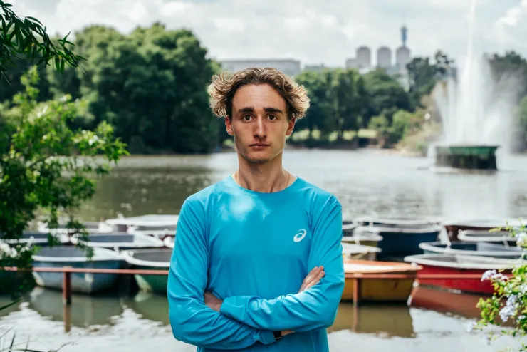 Athlete portrait in a blue running shirt by a lake