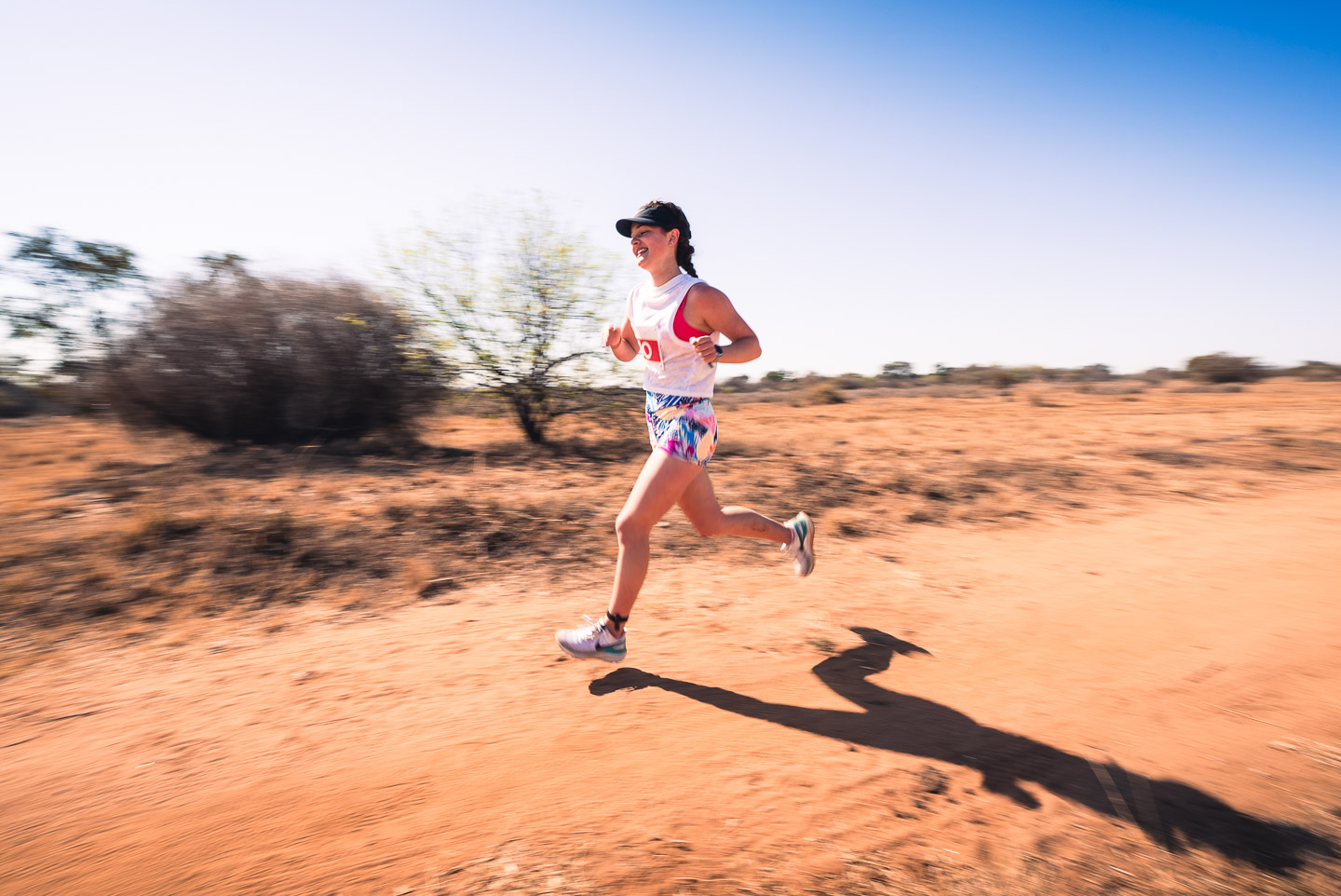 Trail runner captured with motion blur on a dirt road