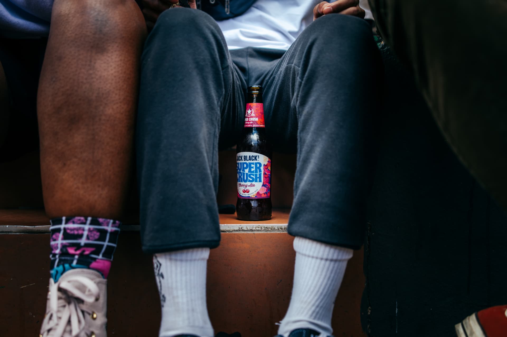 Bottle of Jack Black's Super Crush Cherry Ale on tiled steps