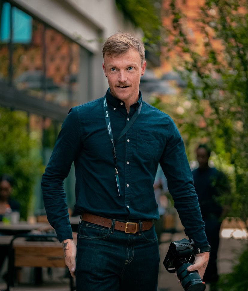 Rory Scheffer outdoors holding a camera